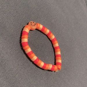 Orange and pink clay bracelet with smiley face